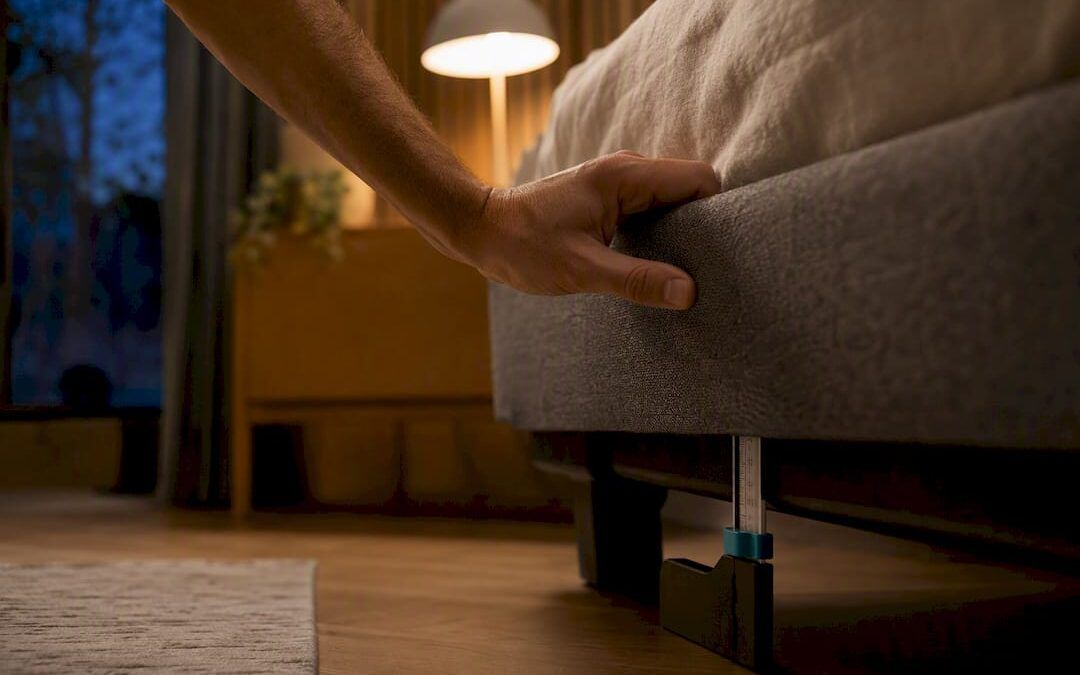 Persona comprobando la estructura de una cama que hace ruido